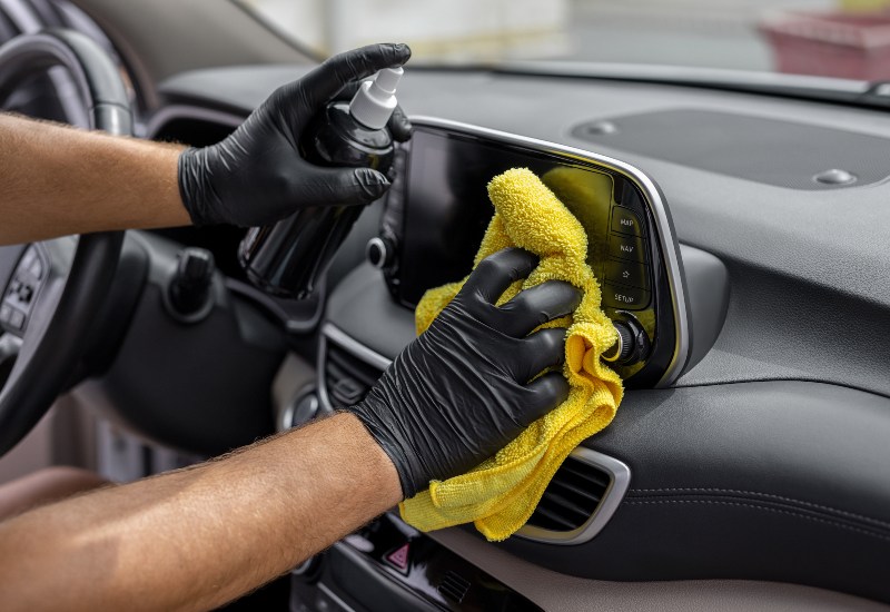 Man Cleaning a Shiny Car for Detailing at Auto Salon of Orlando